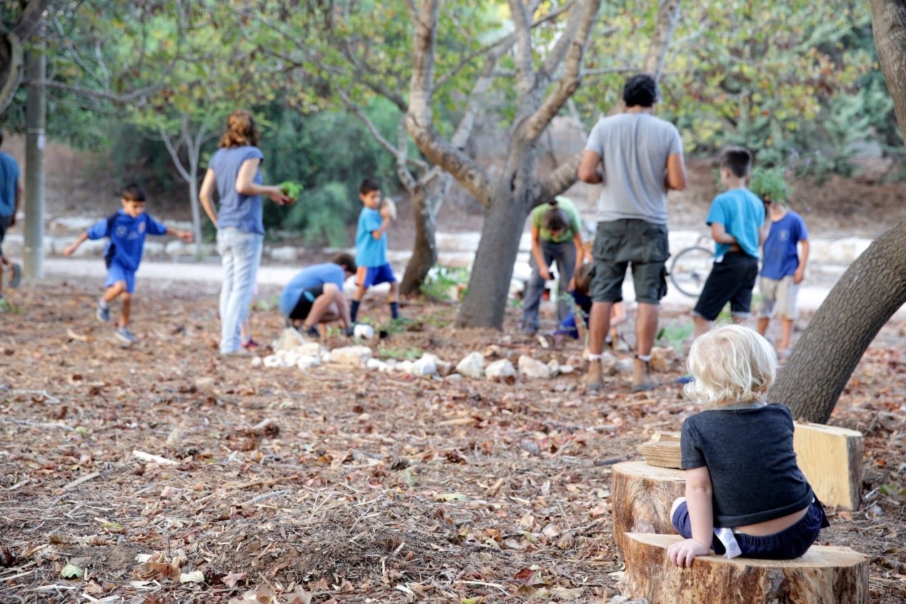 קהילת ילדים ומבוגרים ביער ליד עץ