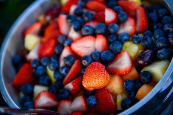 קערה עם פירות חתוכים - תותים, אוכמניות